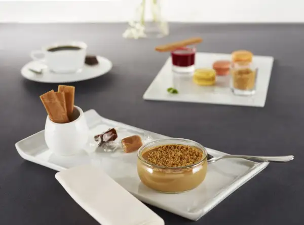 Un café gourmand avec diverses mignardises : crème dessert, macarons, biscuits, chocolats. Parfaites pour des recettes de mignardises pour café gourmand.