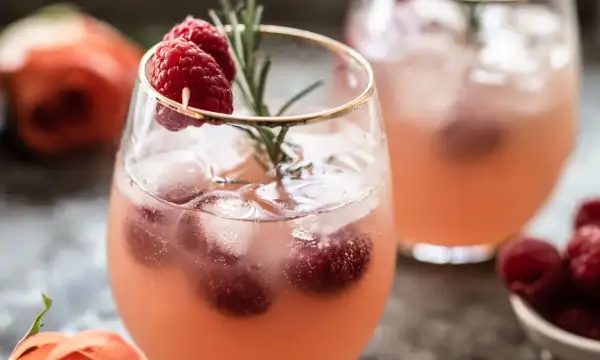 Un délicieux cocktail sans alcool Saint-Valentin, garni de framboises fraîches et d'une touche de romarin. Parfait pour célébrer l'amour !