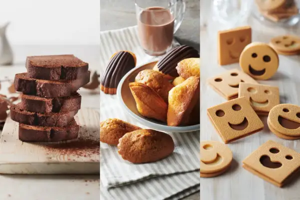 Tranches de cake au chocolat, madeleines et biscuits souriants. Parfait pour une recette goûter gourmande.