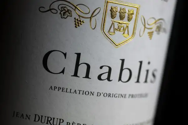 Étiquette d'un Chablis, vin blanc sec ou moelleux, avec un blason doré orné de grappes de raisin.
