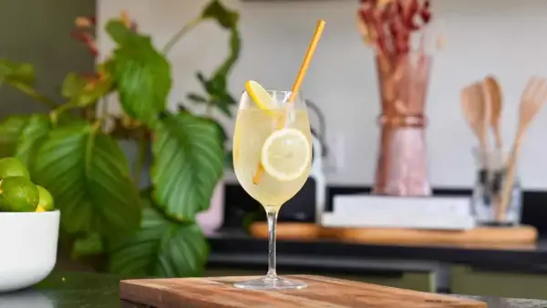 Un cocktail pétillant à la limoncello, garni de rondelles de citron et d'une paille dorée. Une recette rafraîchissante pour l'été.